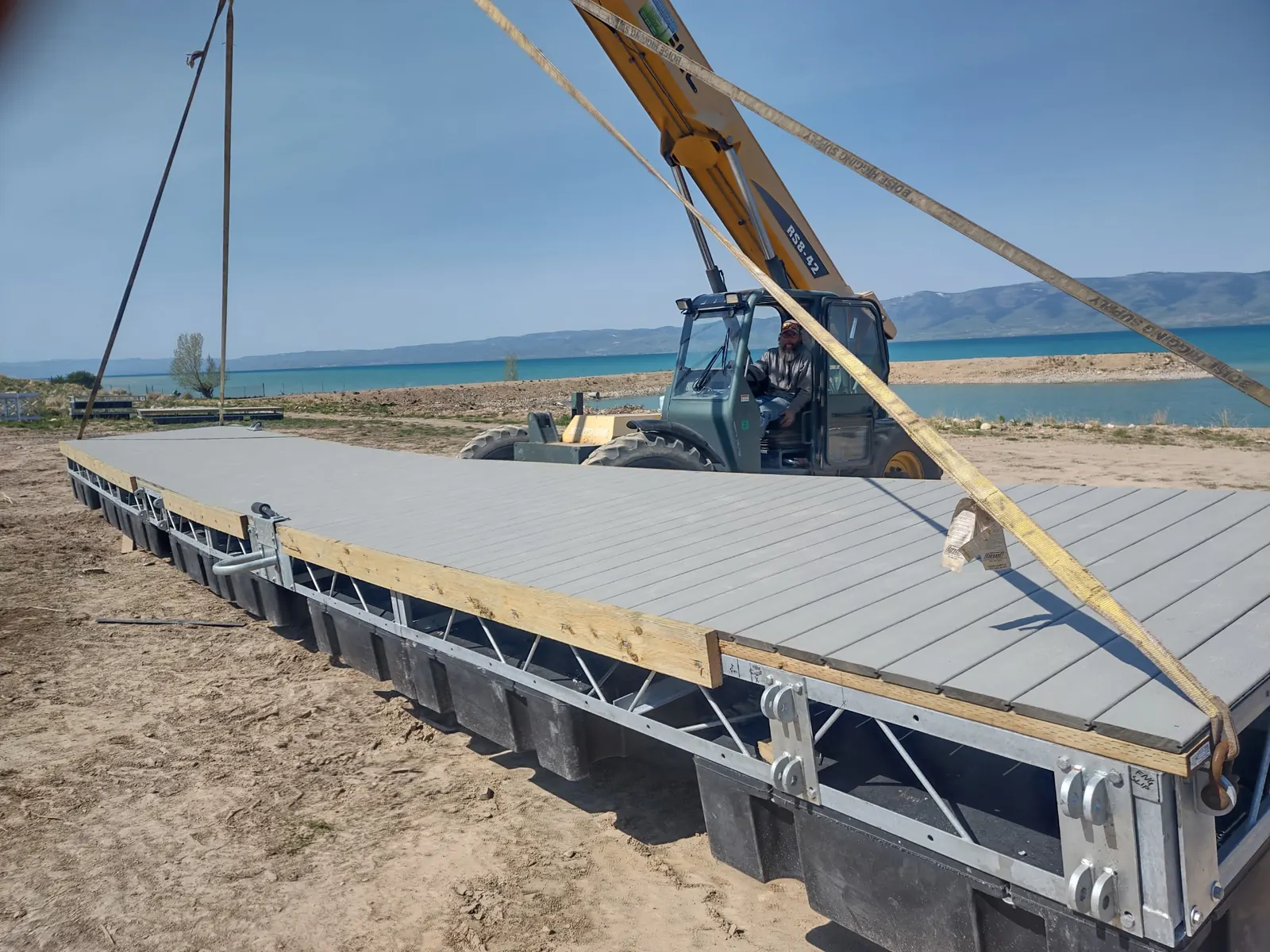 Telehandler rigging a finished steel truss dock section to lift it into Bear Lake